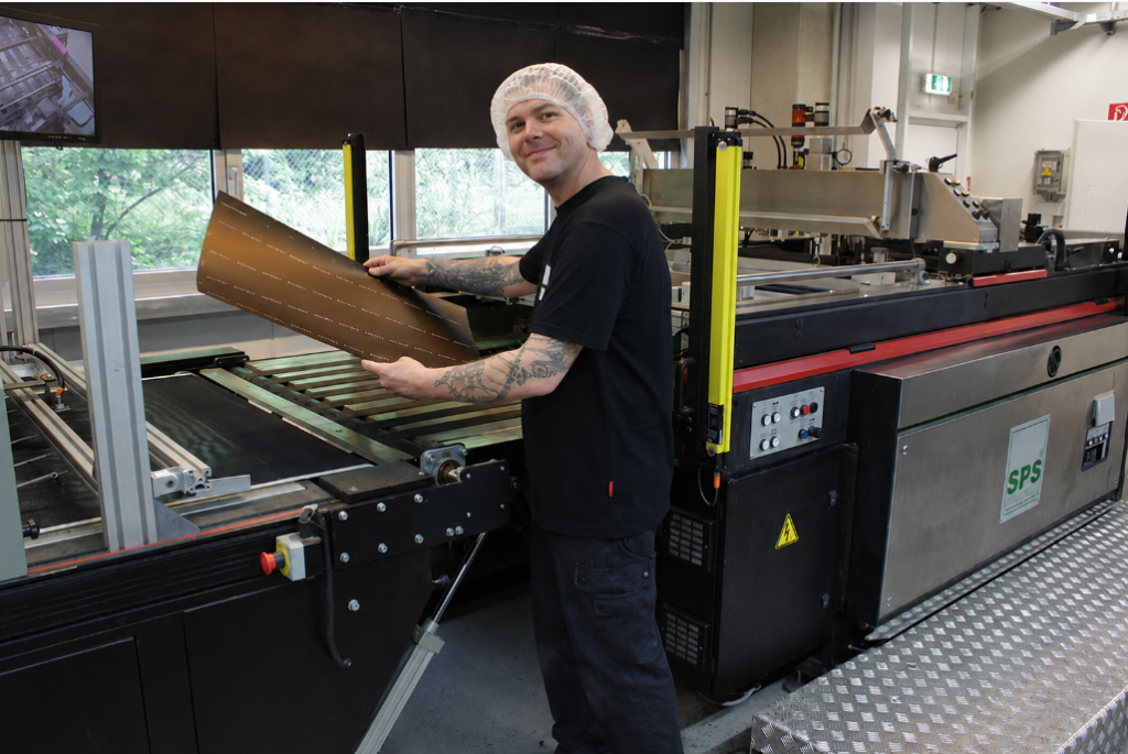 WEROCA employee operating a screen printing machine in Bielefeld – state-of-the-art machinery for custom-finished cardboard packaging.