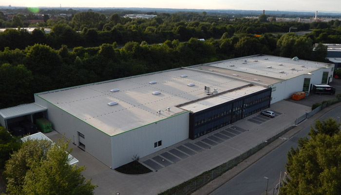 Luftaufnahme des Firmengeländes der WEROCA Kartonagen GmbH & Co. KG in Bielefeld-Hillegossen – beim 50-jährigen Jubiläum 2019 mit über 70 Mitarbeitenden und modernen Produktionshallen