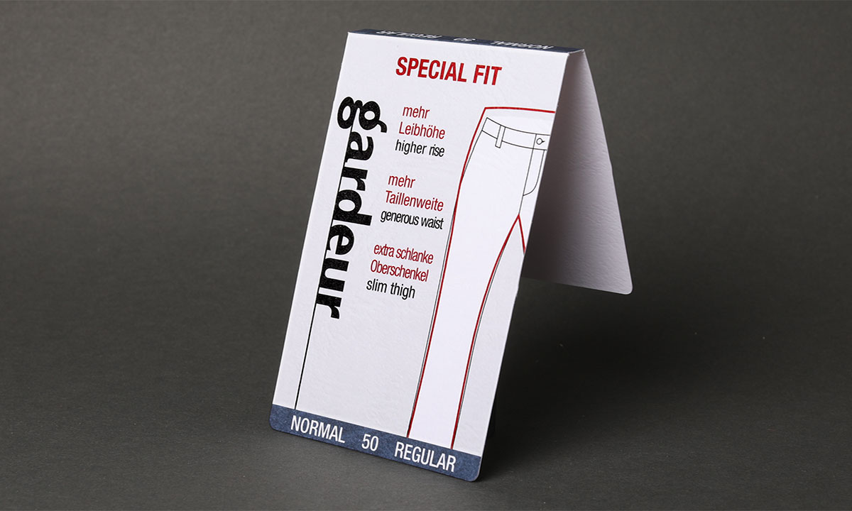 Weißer Bundaufstecker mit rotem „Special Fit"-Aufdruck, zweisprachiger Schnittbeschreibung, Figurskizze und Größenangabe „Normal 50 Regular" für eine Hosenbekleidungsmarke – funktionale Bundaufstecker von WEROCA Kartonagen Bielefeld