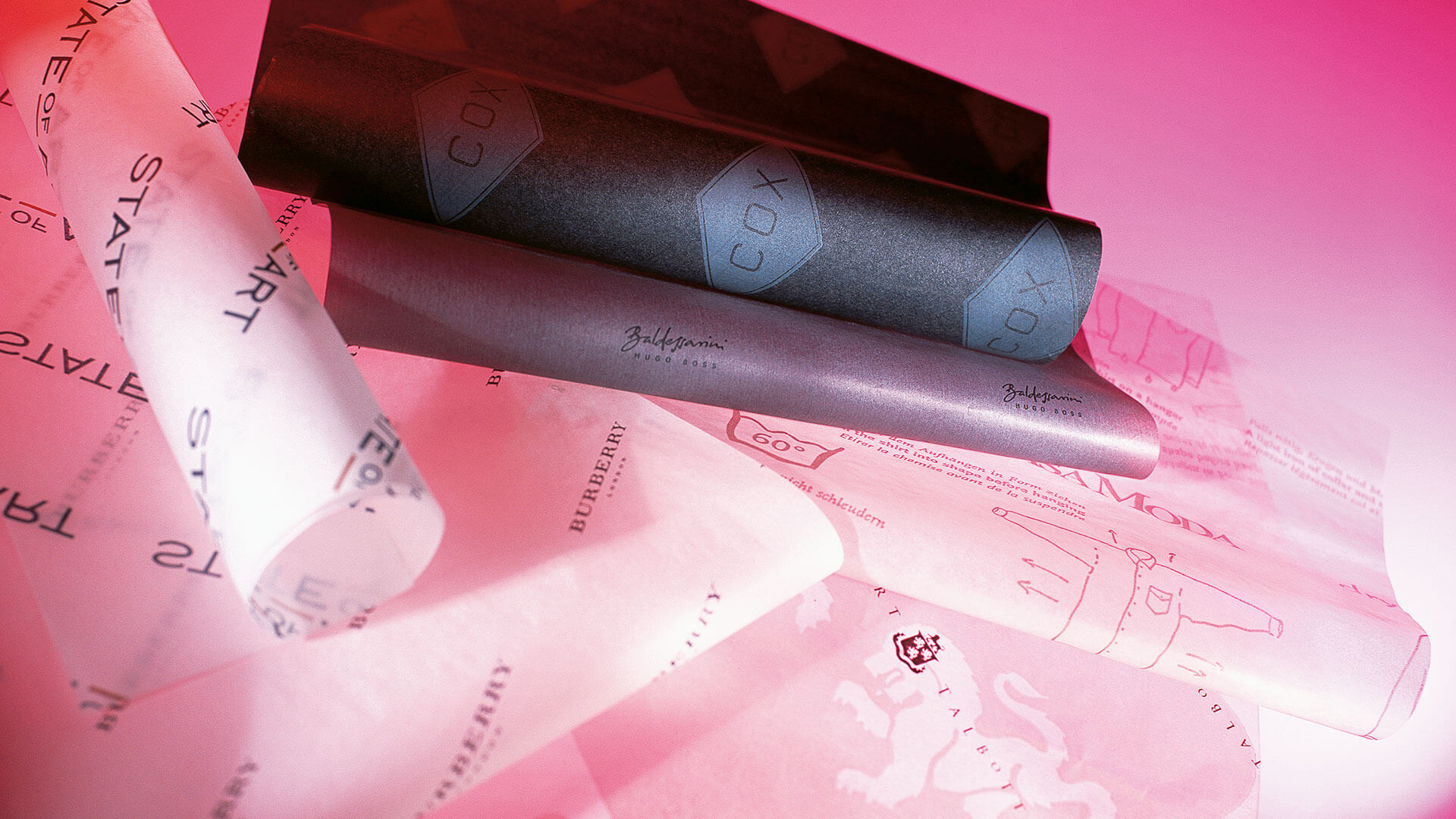 Verschiedene bedruckte Seidenpapiere für Modemarken wie Burberry, Hugo Boss Baldessarini und COX – einfarbig und vollflächig bedruckt als Markenbotschafter beim Auspacken, gefertigt von WEROCA Kartonagen Bielefeld