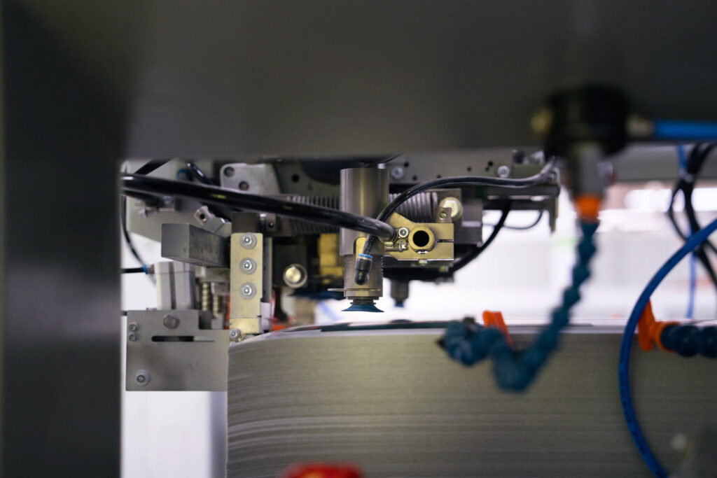 Detailaufnahme des Vakuum-Bogenanlegers einer Stanzmaschine bei WEROCA Kartonagen in Bielefeld – hochpräzise Maschinentechnik für die zuverlässige Kartonverpackungsproduktion