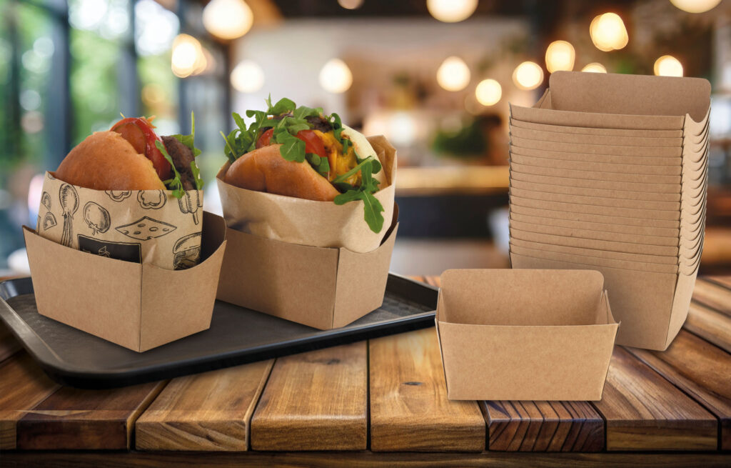 Kraftpapier-Snackschalen von WEROCA Kartonagen Bielefeld gefüllt mit belegten Burgerbrötchen, gestapelt auf einem Holztisch im Gastronomie-Ambiente, Lagerprogramm für Food & Gastronomie.