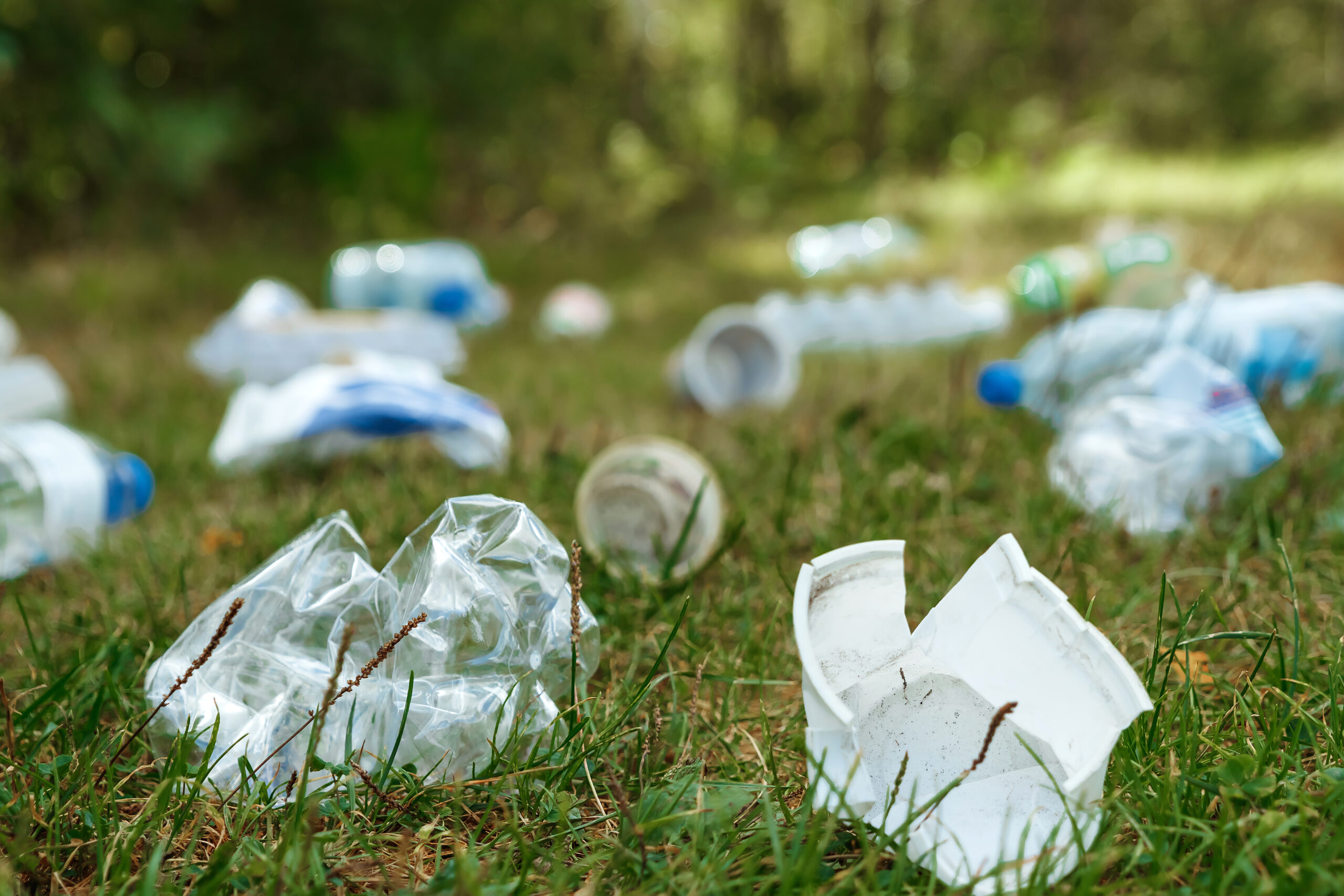 A pile of plastic on green grass, a problem in the natural environment, pollution of nature is not decomposing plastic. Protection of Nature.