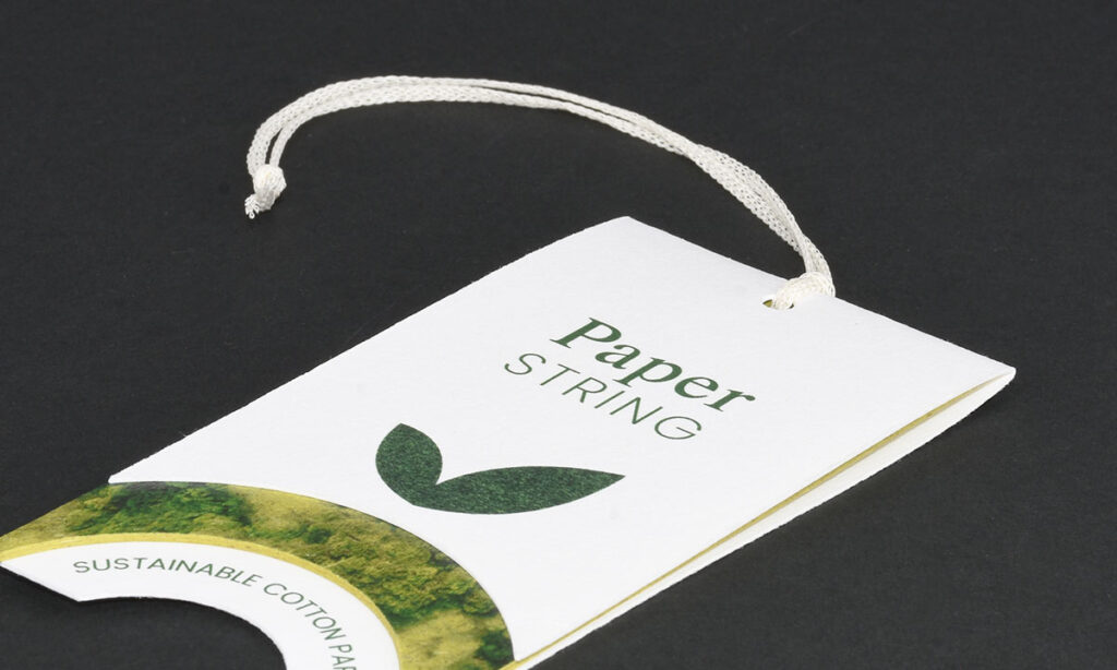 Weißes "Paper String"-Hangtag von WEROCA Kartonagen Bielefeld mit Blattlogo und "Sustainable Cotton Paper"-Hinweis, Detailaufnahme für Fashion & Textil-Hangtags.
